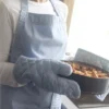 Vrouw met ovenhandschoenen houdt warme appeltaart vast.