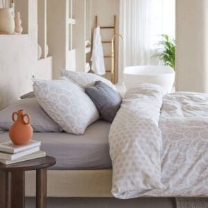 Comfortabel bed met decoratieve kussens en vaas