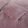 Roze fluwelen geribbelde kussen op bed