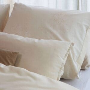 Beige kussensloop met bloemenpatroon op bed