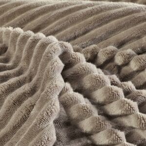 Zachte, beige pluchen deken met ribbels.