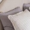 Kussens op bed met geruite kussensloop