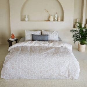 Stijlvol bed met patroon dekbedovertrek en kussens.