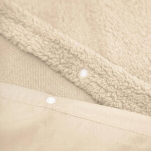 Detail van beige zachte deken met knopen.