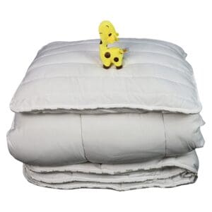 Gewatteerd dekbed met pluche giraffe erbovenop.