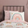 Regenboogdekbedovertrek met hartjes op bed