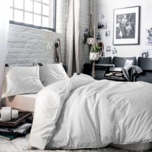 Moderne slaapkamer met wit beddengoed en kunstwerken.