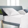 Strak wit beddengoed op modern bed