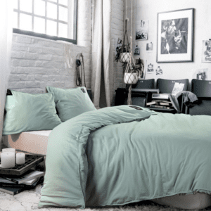 Lichte slaapkamer met groene dekbedset en decoraties.